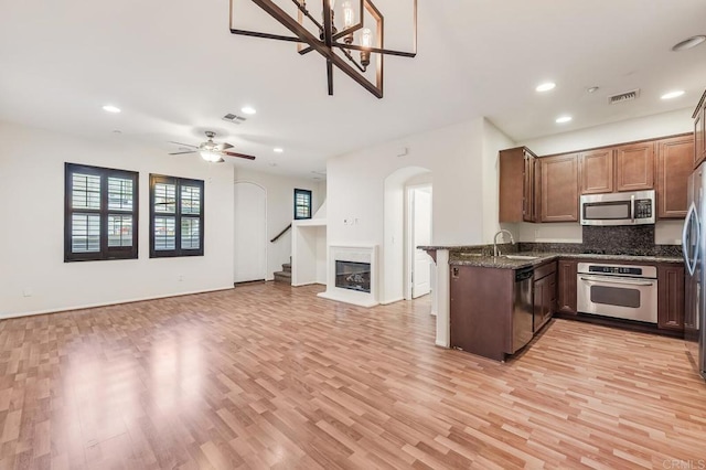 kitchen with stainless steel appliances, arched walkways, visible vents, and a sink