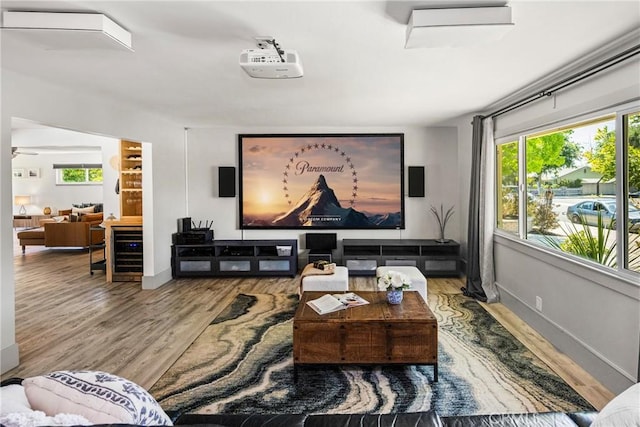 living room featuring a healthy amount of sunlight, wood finished floors, and beverage cooler