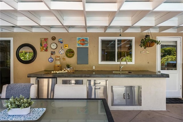 exterior space with beamed ceiling, coffered ceiling, freestanding refrigerator, and a sink