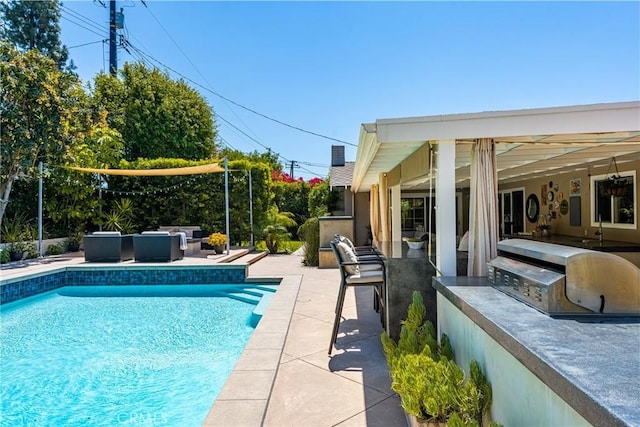 outdoor pool featuring an outdoor living space, a patio area, grilling area, and exterior kitchen