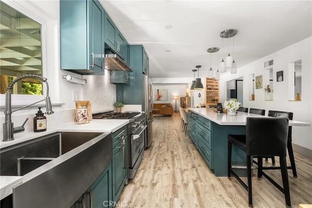 kitchen featuring light wood-style floors, appliances with stainless steel finishes, light countertops, a sink, and visible vents