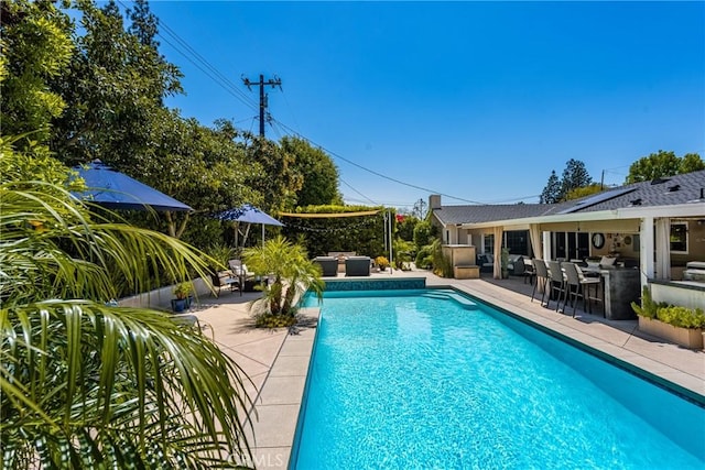 outdoor pool with a patio area and an outdoor living space