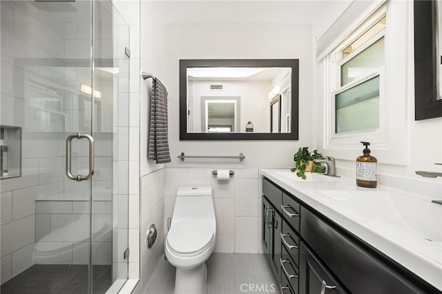 bathroom with a shower stall, toilet, double vanity, and a sink