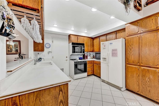 kitchen featuring a sink, brown cabinetry, range with gas stovetop, white fridge with ice dispenser, and light tile patterned floors