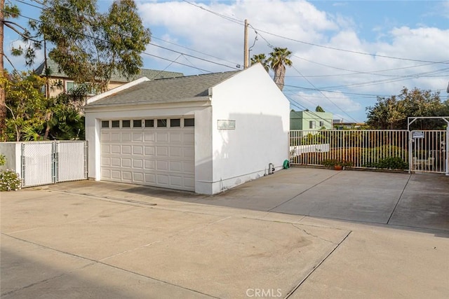detached garage featuring a gate and fence