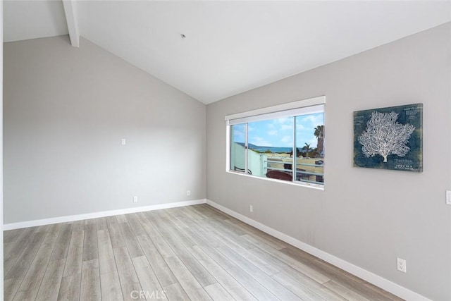 unfurnished room featuring baseboards, lofted ceiling with beams, and wood finished floors