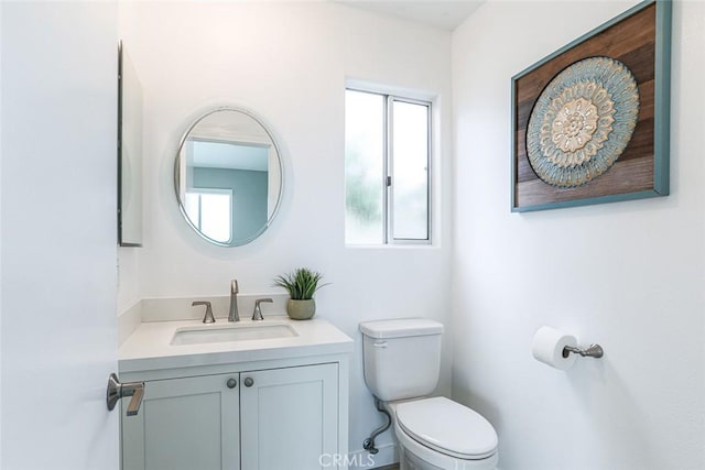 half bath featuring vanity and toilet
