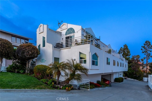 exterior space with a garage, stucco siding, and concrete driveway