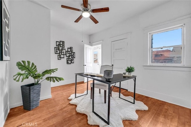 office space featuring baseboards, wood finished floors, and ceiling fan