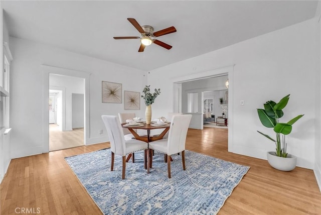 dining area featuring light wood-style floors and a ceiling fan
