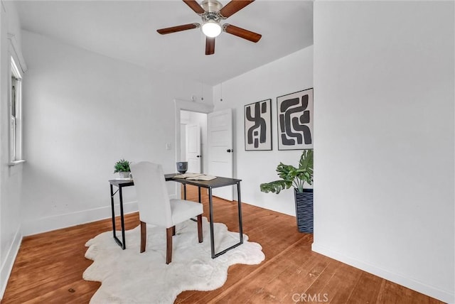 home office featuring wood finished floors, ceiling fan, and baseboards