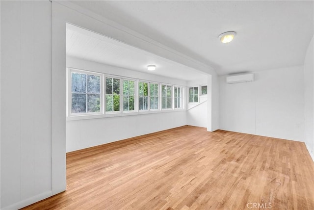 spare room with wood finished floors and a wall mounted AC