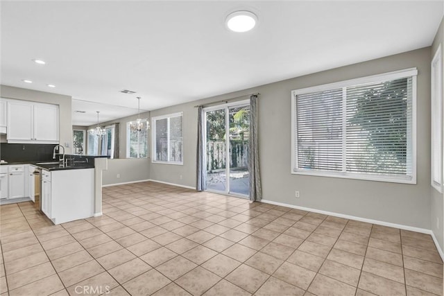 11 Santa Cruz Aisle, Irvine, CA 92606 - kitchen featuring light tile patterned floors, dark countertops, white cabinetry, a notable chandelier, and a peninsula