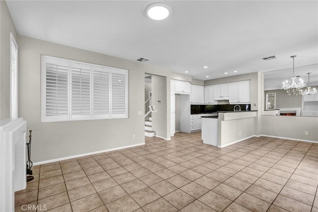 11 Santa Cruz Aisle, Irvine, CA 92606 - kitchen with light tile patterned floors, visible vents, a peninsula, white cabinets, and open floor plan
