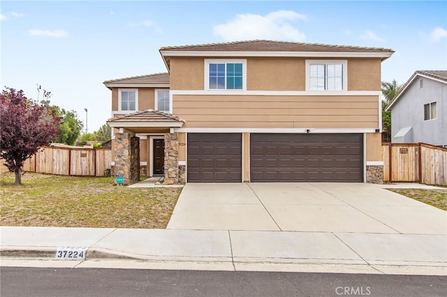 traditional home with stucco siding, fence, an attached garage, and stone siding