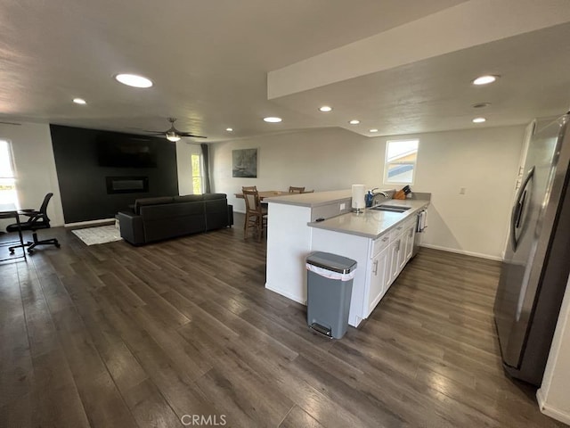 kitchen with a healthy amount of sunlight, white cabinets, freestanding refrigerator, and a sink