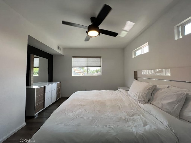 bedroom with baseboards, a ceiling fan, dark wood-type flooring, and visible vents