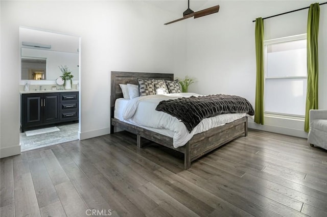 bedroom featuring baseboards, a ceiling fan, ensuite bath, and hardwood / wood-style flooring