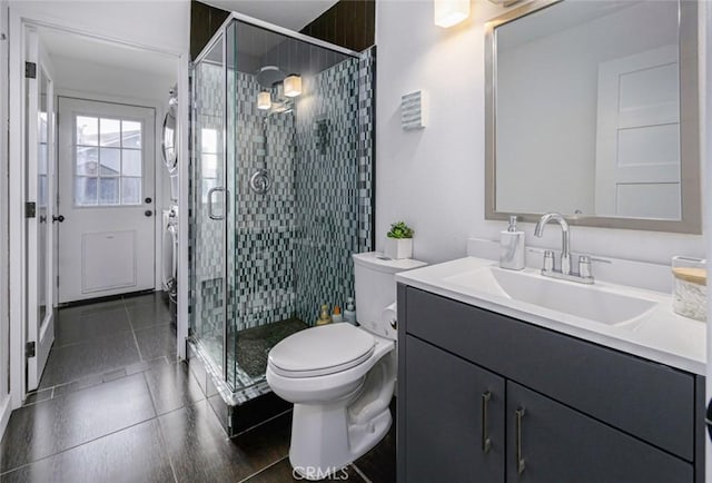 bathroom featuring vanity, tile patterned floors, a stall shower, and toilet
