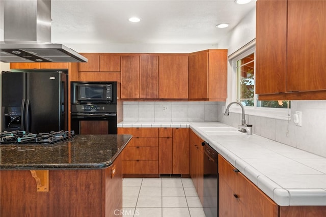 kitchen with brown cabinets, island range hood, black appliances, and a sink