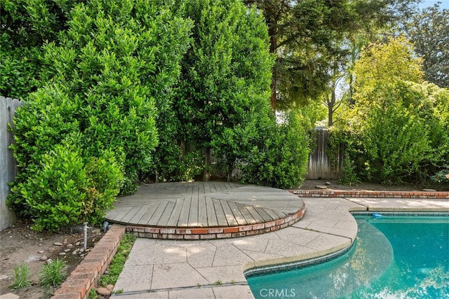 view of swimming pool featuring a fenced backyard, a wooden deck, and a fenced in pool