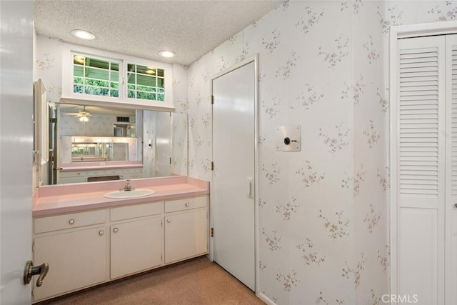 bathroom featuring a closet, wallpapered walls, and a textured ceiling