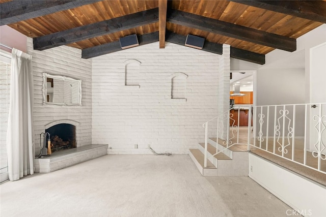 unfurnished living room with carpet flooring, wood ceiling, lofted ceiling with beams, a brick fireplace, and brick wall