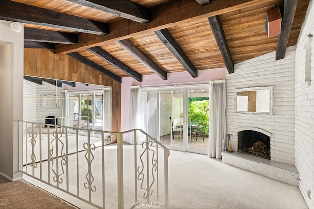 unfurnished living room with lofted ceiling with beams, wood ceiling, carpet floors, and a healthy amount of sunlight