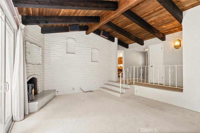 unfurnished living room with lofted ceiling with beams, wood ceiling, brick wall, and carpet floors