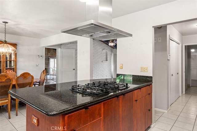 kitchen featuring exhaust hood, hanging light fixtures, light tile patterned flooring, dark stone counters, and black gas stovetop