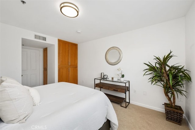 bedroom with light colored carpet and baseboards