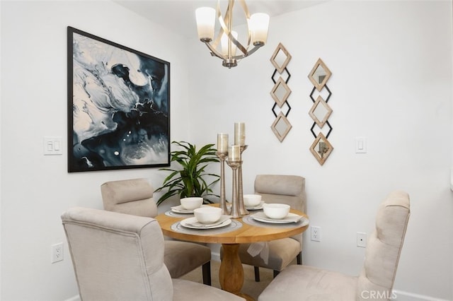 dining area featuring a chandelier and baseboards