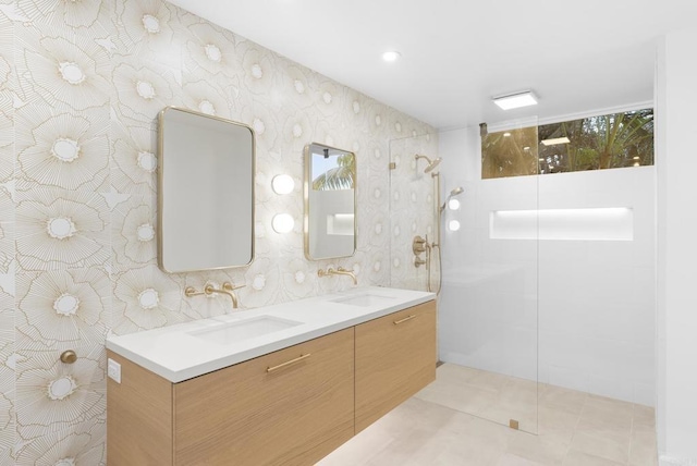 full bath featuring walk in shower, double vanity, a sink, and tile patterned floors