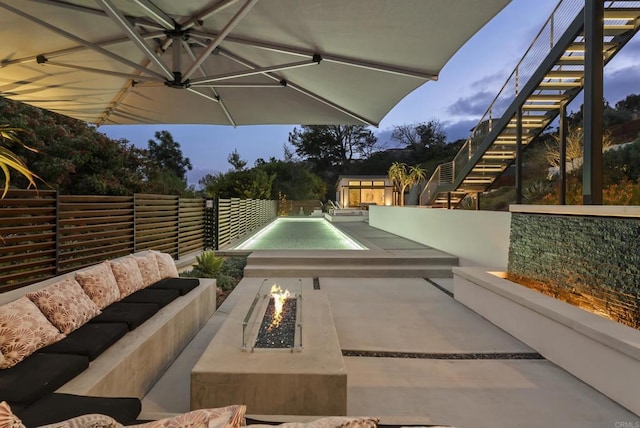 view of patio / terrace featuring stairs, fence, and an outdoor fire pit