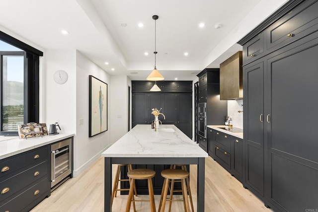 kitchen with tasteful backsplash, beverage cooler, plenty of natural light, recessed lighting, and light wood finished floors