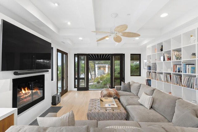 living room with recessed lighting, a fireplace with flush hearth, ceiling fan, coffered ceiling, and wood finished floors