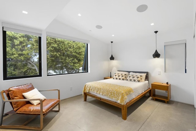 bedroom featuring finished concrete flooring and vaulted ceiling