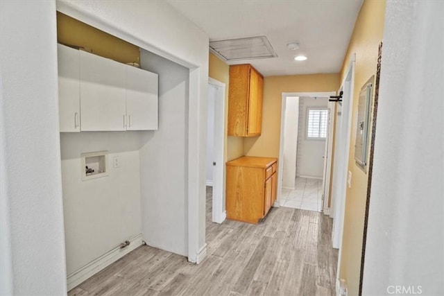 clothes washing area featuring cabinet space, baseboards, light wood-style flooring, and hookup for a washing machine