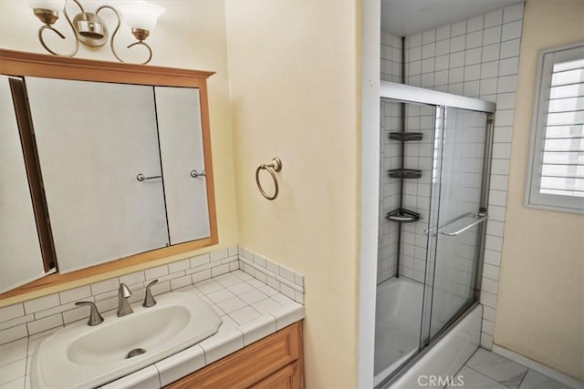 full bathroom featuring marble finish floor, bath / shower combo with glass door, and vanity