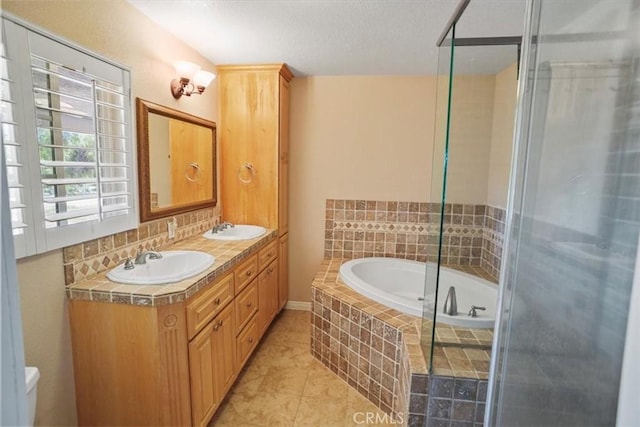 bathroom with a garden tub, a sink, a stall shower, and double vanity