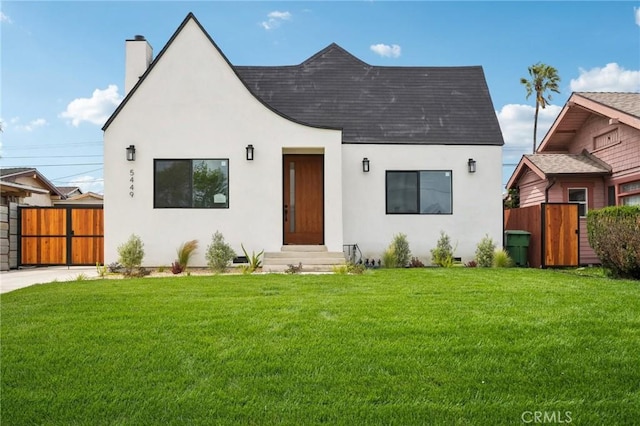 view of front of house with fence, stucco siding, and a chimney