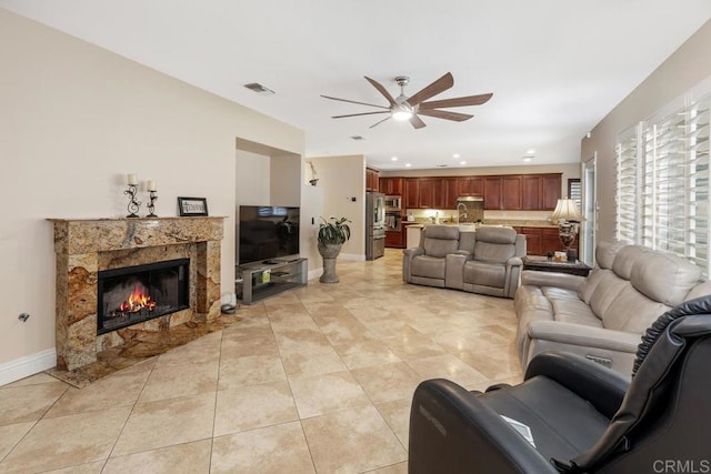 living room with recessed lighting, light tile patterned floors, a premium fireplace, visible vents, and a ceiling fan