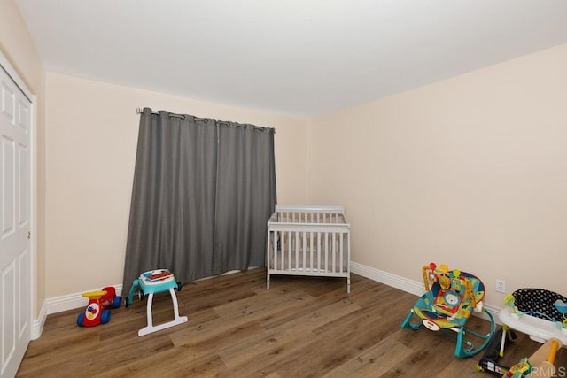 unfurnished bedroom with baseboards, wood finished floors, and a closet