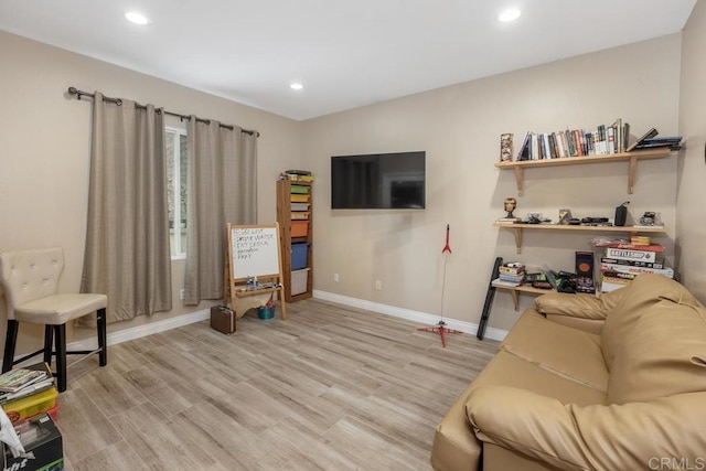 living room featuring baseboards, recessed lighting, and light wood-style floors
