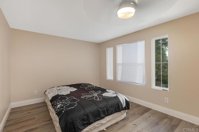bedroom featuring baseboards and wood finished floors
