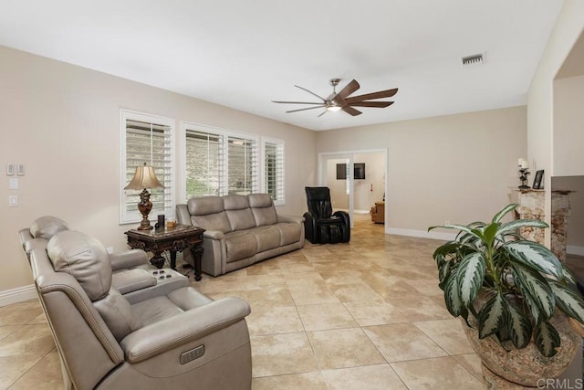 living area with light tile patterned floors, ceiling fan, baseboards, and visible vents
