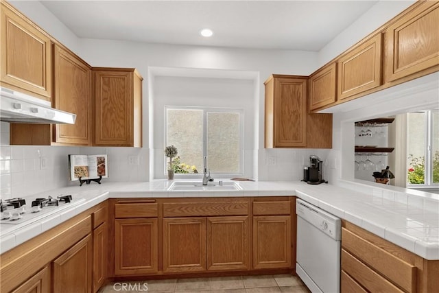 kitchen featuring a sink, white appliances, recessed lighting, decorative backsplash, and under cabinet range hood