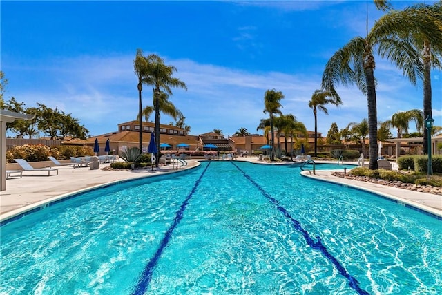 community pool featuring fence and a patio
