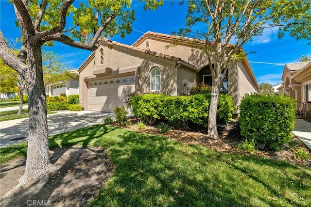 mediterranean / spanish-style house with a front lawn, a garage, stucco siding, concrete driveway, and a tiled roof