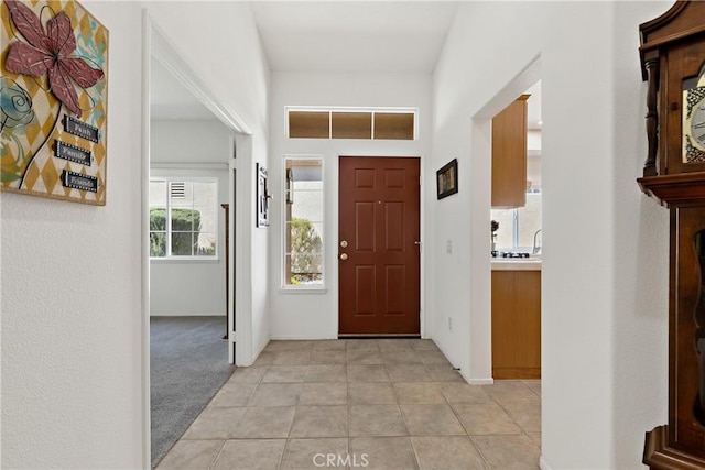 foyer with light colored carpet and light tile patterned floors